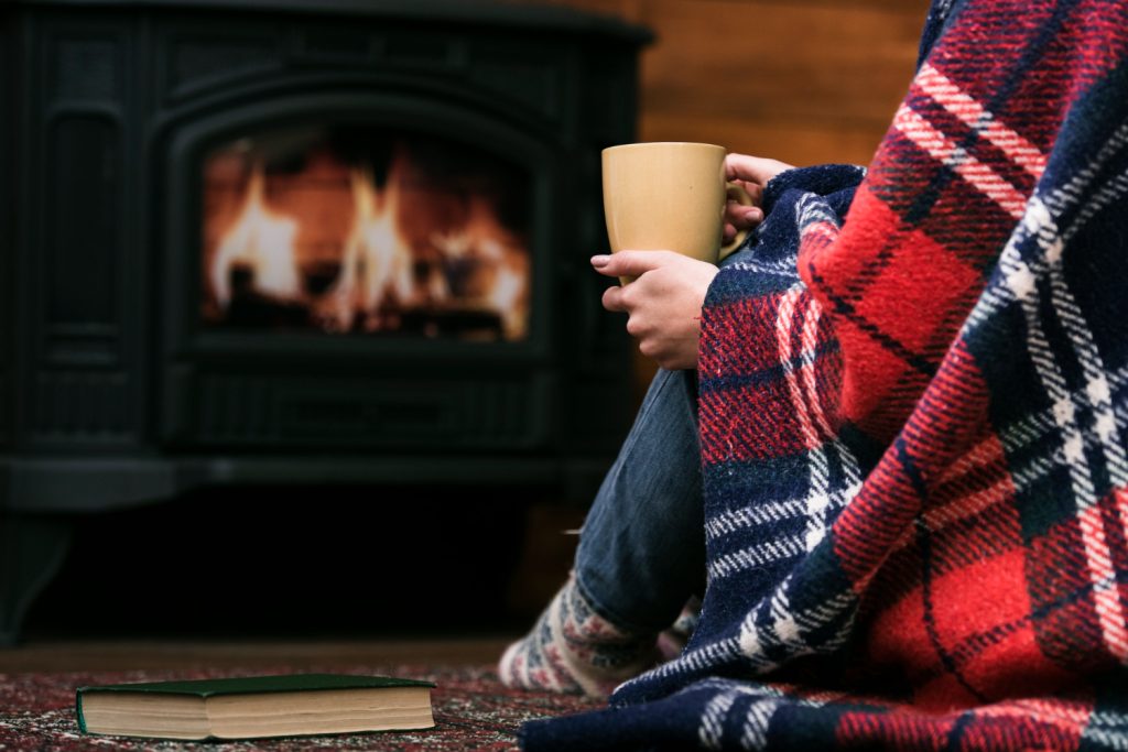 sipping tea in mug by the fire - things to buy for your kitchen